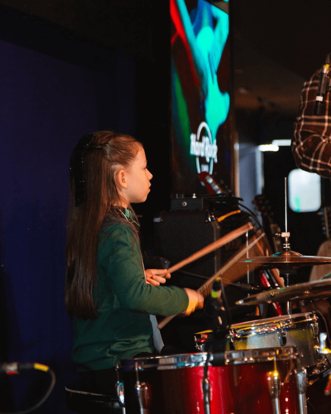 Criança em aula de bateria na Vibrato Porto Alegre – curso infantil de bateria.
